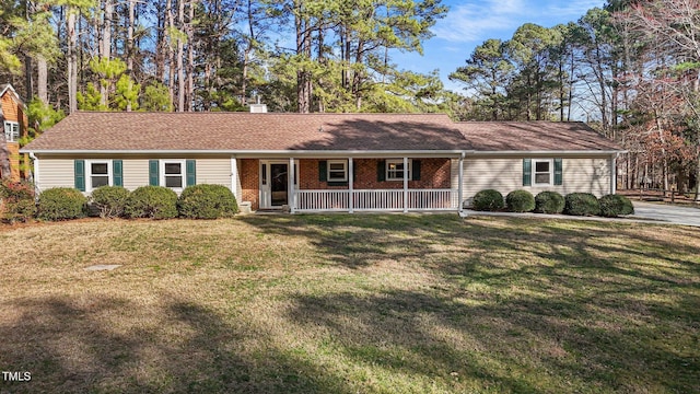 single story home with covered porch, a chimney, a front lawn, and brick siding