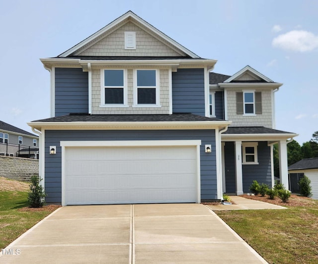 28 Longdale Dr, Graham, NC 27253 - view of front of home featuring concrete driveway, a garage, covered porch, a front lawn, and roof with shingles