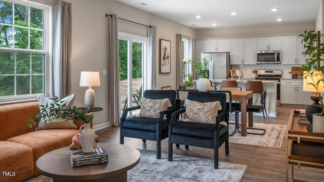 living room with baseboards, wood finished floors, and recessed lighting