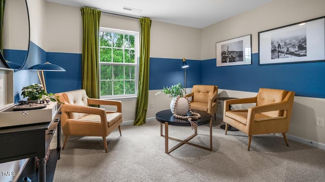 living area featuring carpet flooring, visible vents, and baseboards