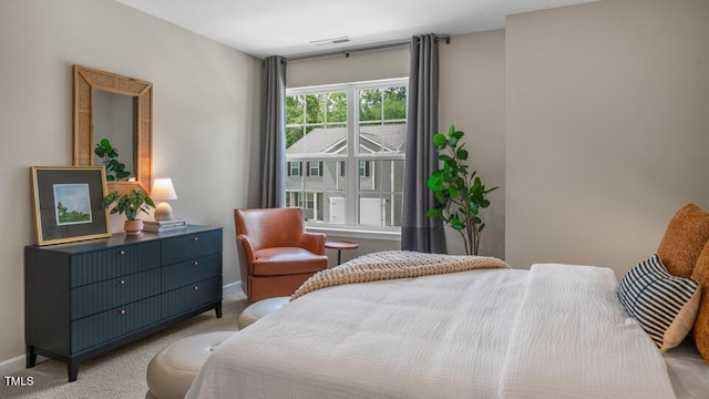 bedroom featuring light carpet and baseboards