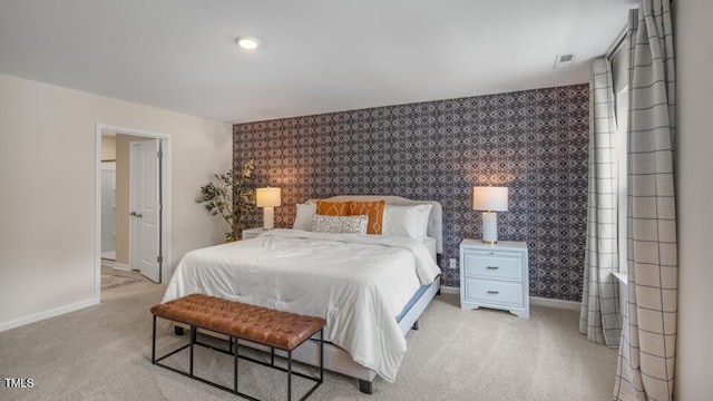 bedroom featuring light carpet, an accent wall, baseboards, and wallpapered walls