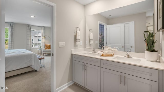 ensuite bathroom with double vanity, a sink, baseboards, and ensuite bathroom