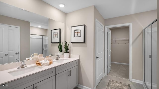 full bath featuring double vanity, a shower stall, and a sink