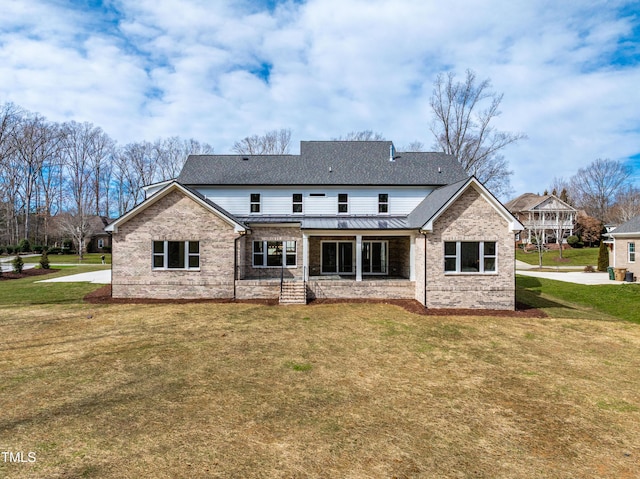 back of house with metal roof, a yard, brick siding, and a shingled roof