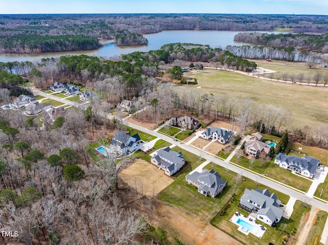 birds eye view of property featuring a water view and a view of trees