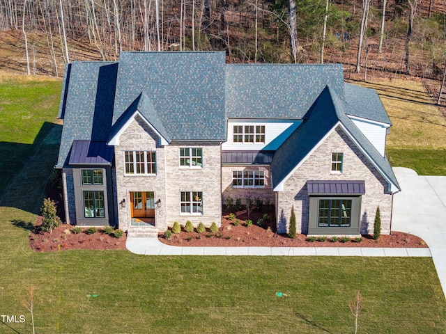 view of front of home featuring a standing seam roof, a front lawn, metal roof, and roof with shingles