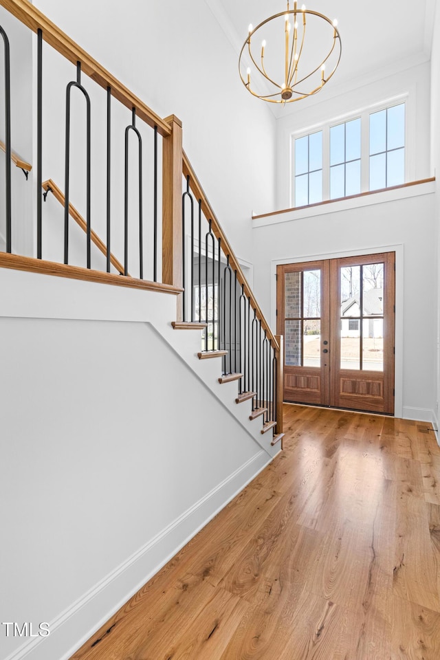 foyer entrance with stairs, french doors, wood finished floors, and baseboards