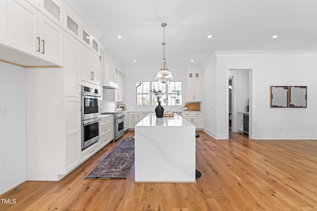 kitchen with a center island, stainless steel appliances, backsplash, ornamental molding, and beverage cooler