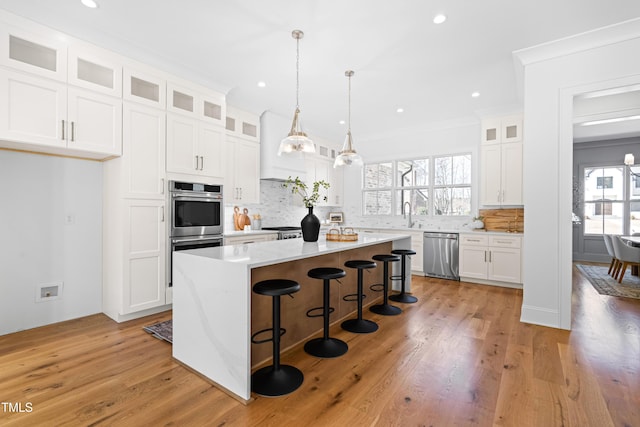 kitchen featuring a breakfast bar, stainless steel appliances, light countertops, decorative backsplash, and a kitchen island