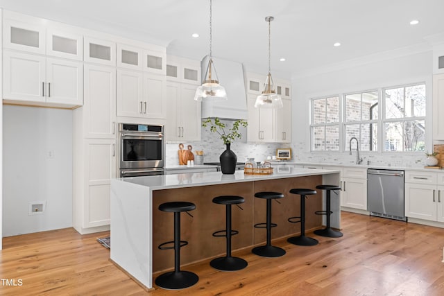 kitchen with stainless steel appliances, a center island, white cabinetry, and tasteful backsplash