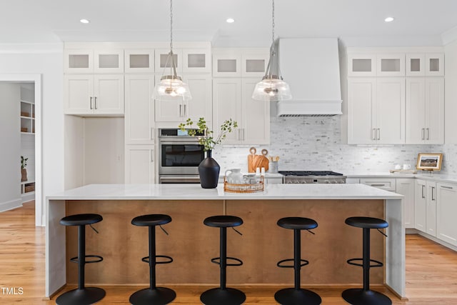 kitchen with decorative backsplash, a kitchen island, custom exhaust hood, light wood-type flooring, and white cabinetry