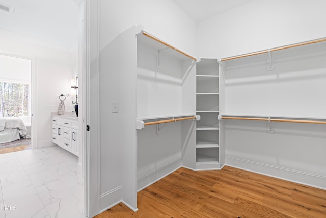 walk in closet featuring marble finish floor and visible vents