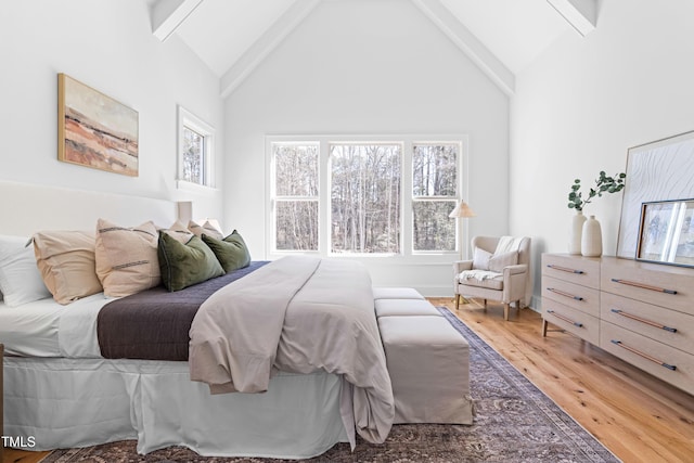 bedroom featuring light wood finished floors, high vaulted ceiling, and beam ceiling