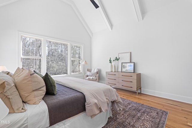 bedroom featuring high vaulted ceiling, beamed ceiling, wood finished floors, and baseboards