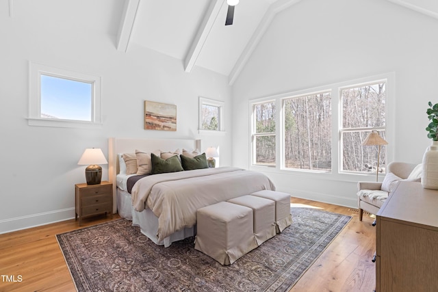 bedroom featuring high vaulted ceiling, light wood finished floors, beamed ceiling, and baseboards