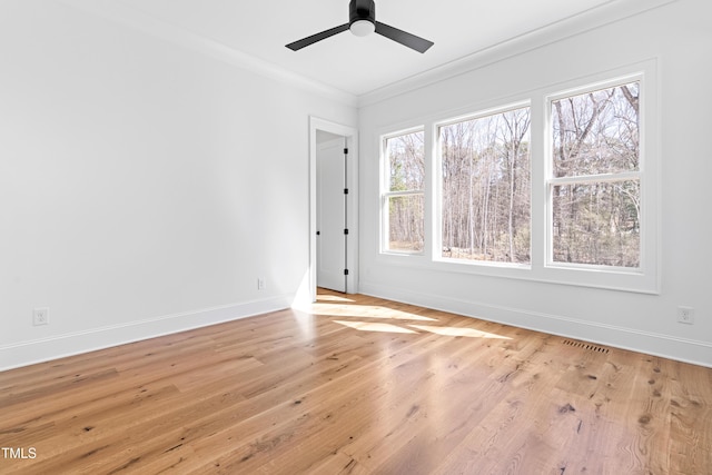 unfurnished room with visible vents, crown molding, baseboards, and wood finished floors