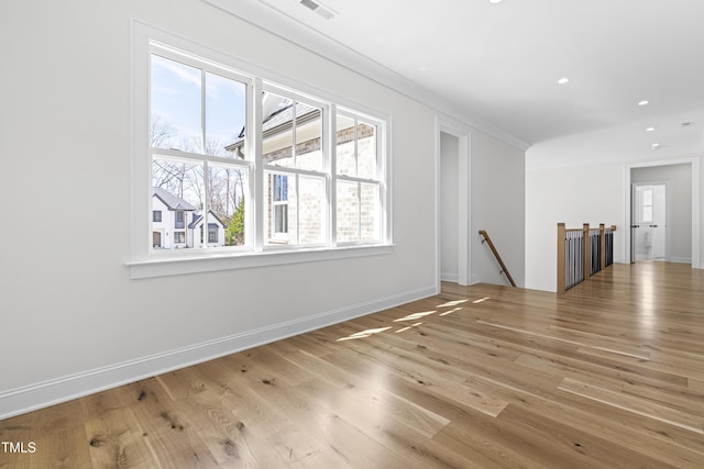 empty room featuring baseboards, visible vents, ornamental molding, wood finished floors, and recessed lighting