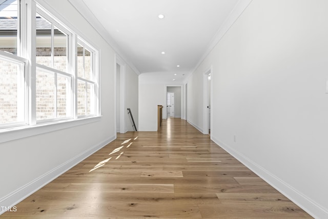 corridor with baseboards, crown molding, an upstairs landing, light wood-style floors, and recessed lighting