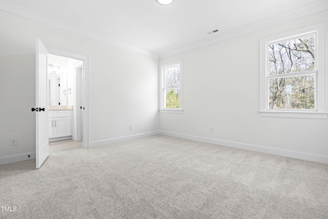 unfurnished bedroom with baseboards, visible vents, ornamental molding, and light colored carpet