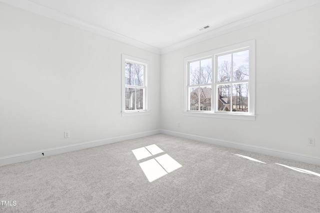 unfurnished room with carpet flooring, crown molding, visible vents, and baseboards