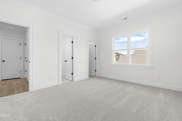 unfurnished bedroom featuring ornamental molding, carpet, and baseboards