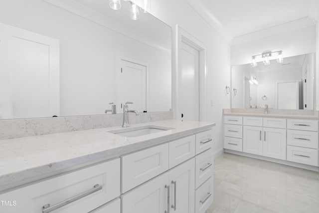 full bathroom featuring ornamental molding, two vanities, and a sink