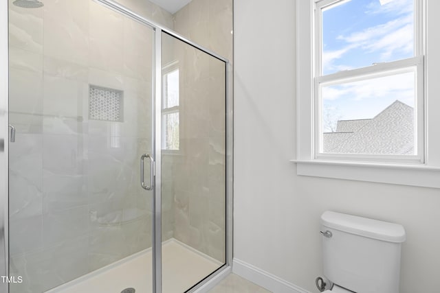 full bathroom with a stall shower, a wealth of natural light, and toilet