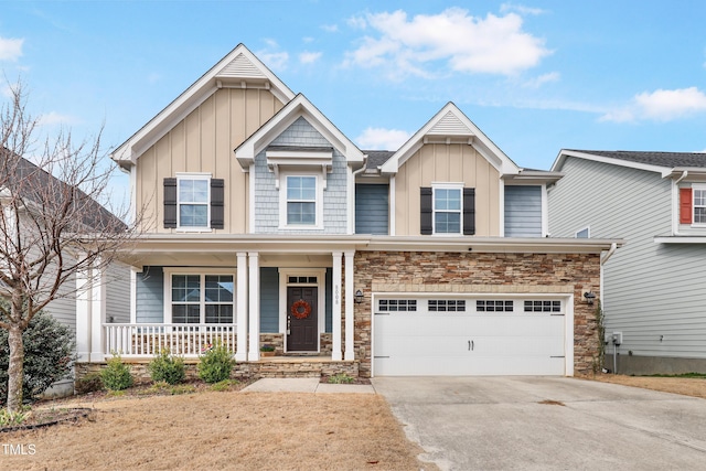 view of front of property with a porch, an attached garage, stone siding, concrete driveway, and board and batten siding