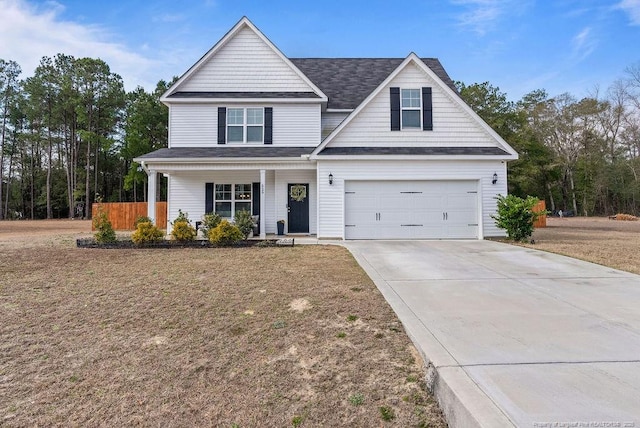 view of front facade featuring driveway, covered porch, an attached garage, and a front lawn