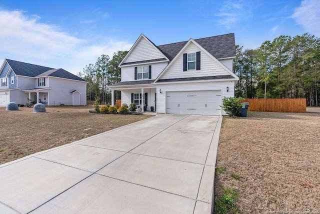 view of front of home with driveway, an attached garage, and fence