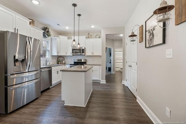 kitchen with appliances with stainless steel finishes, white cabinetry, and backsplash