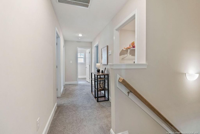 corridor featuring carpet flooring, visible vents, and baseboards