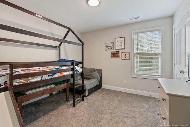 bedroom featuring baseboards, visible vents, and light colored carpet