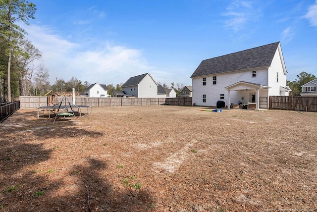 view of yard featuring a trampoline and a fenced backyard