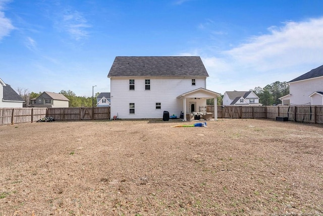 rear view of house featuring a fenced backyard