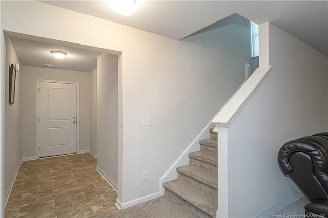 stairway featuring visible vents and baseboards