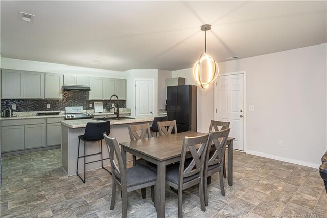 dining area featuring stone finish flooring, visible vents, and baseboards