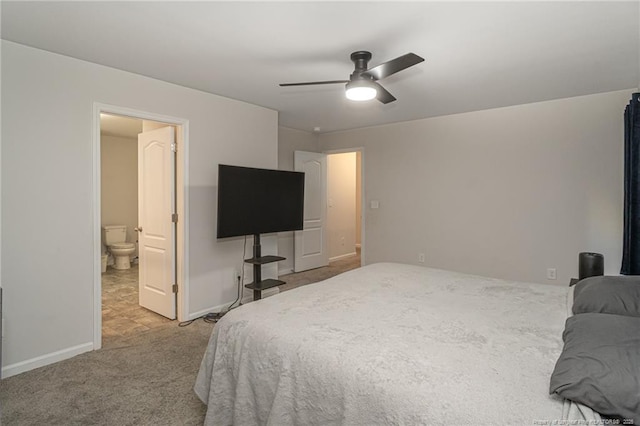 bedroom featuring a ceiling fan, ensuite bath, baseboards, and carpet flooring