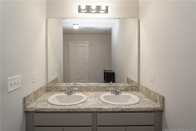 bathroom featuring a sink and double vanity