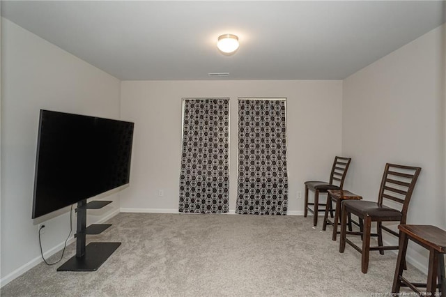 living area with carpet floors, visible vents, and baseboards