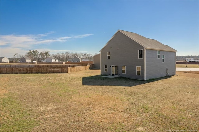 back of property with a yard and fence