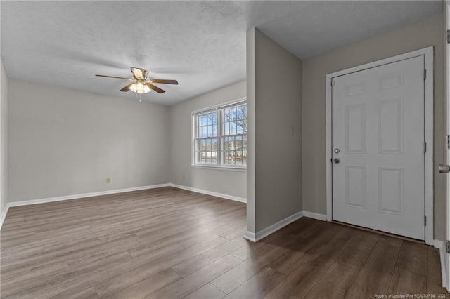 entryway with a ceiling fan, a textured ceiling, baseboards, and wood finished floors