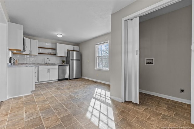 kitchen featuring decorative backsplash, stainless steel appliances, light countertops, white cabinetry, and open shelves