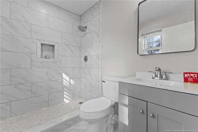 full bath with a tile shower, marble finish floor, vanity, and toilet