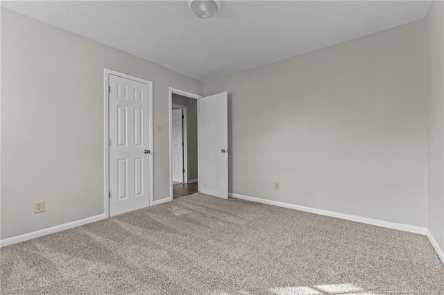 unfurnished bedroom featuring carpet floors and baseboards