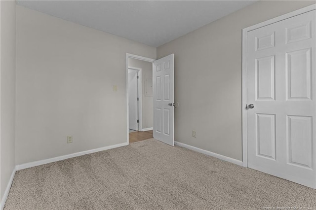 unfurnished bedroom featuring carpet and baseboards