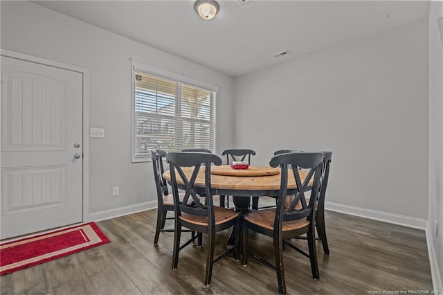 dining space featuring dark wood finished floors, visible vents, and baseboards