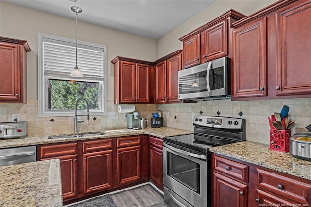 kitchen with appliances with stainless steel finishes, a sink, and dark brown cabinets