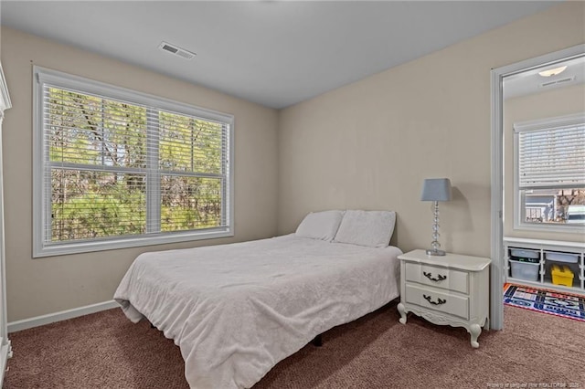 carpeted bedroom with multiple windows, visible vents, and baseboards